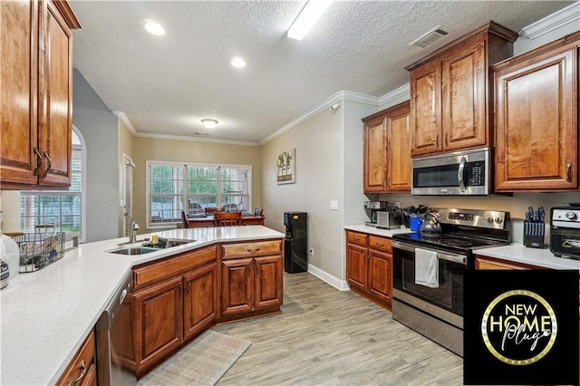 kitchen featuring appliances with stainless steel finishes, light countertops, and a sink