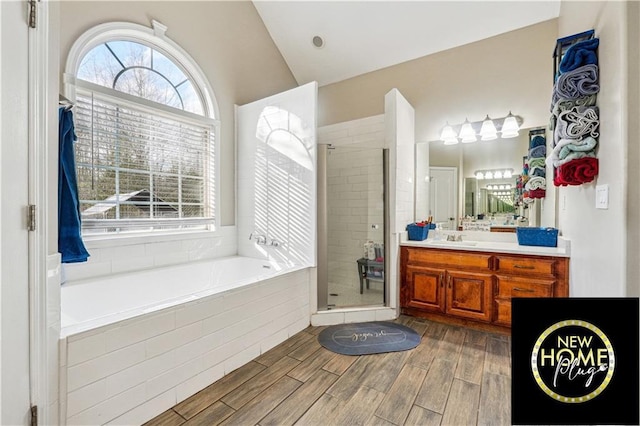 bathroom featuring lofted ceiling, plenty of natural light, a shower stall, and wood tiled floor