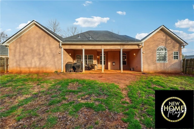 back of property featuring a patio, a yard, fence, and stucco siding