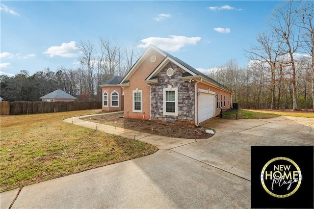 exterior space with a lawn, an attached garage, fence, stone siding, and driveway