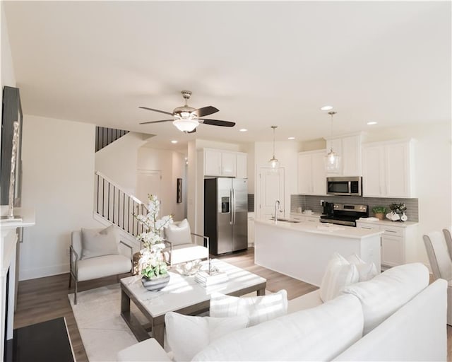 living room featuring ceiling fan, sink, and light hardwood / wood-style floors