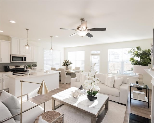 living room featuring ceiling fan and a wealth of natural light