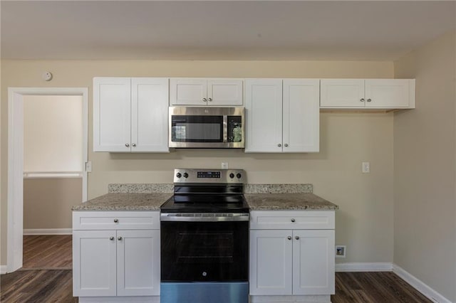 kitchen featuring light stone counters, appliances with stainless steel finishes, dark hardwood / wood-style flooring, and white cabinets