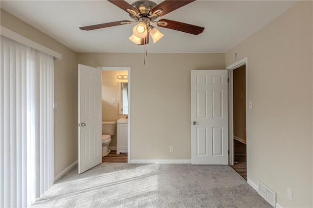 unfurnished bedroom featuring ceiling fan, light colored carpet, and ensuite bathroom