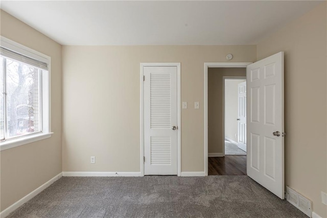 unfurnished bedroom with dark carpet