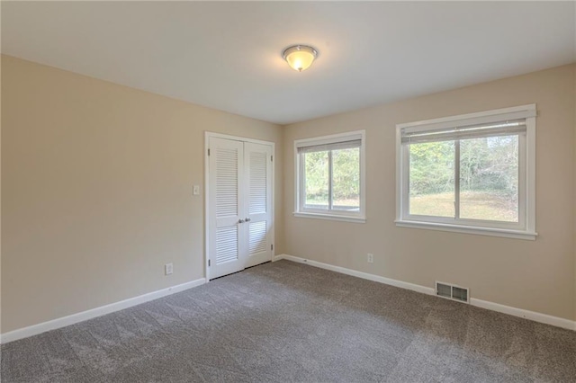 unfurnished bedroom featuring carpet flooring and a closet