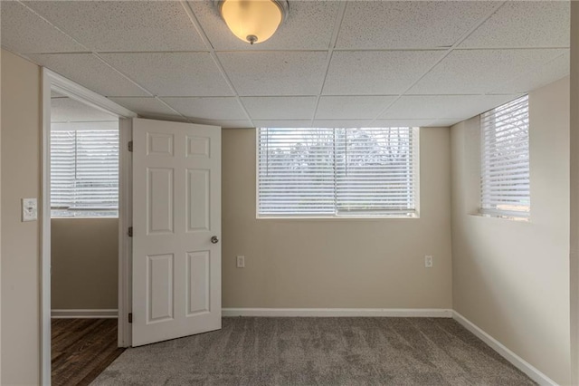 unfurnished room featuring carpet flooring and a drop ceiling