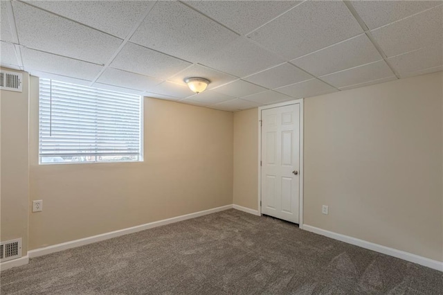 spare room with a drop ceiling and carpet