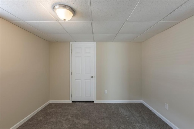 carpeted spare room with a drop ceiling