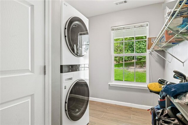 5706 Forest Pl, Acworth, GA 30102 - laundry room with stacked washer and clothes dryer, healthy amount of natural light, and wood finished floors