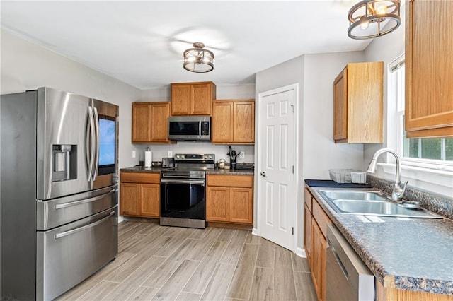 5706 Forest Pl, Acworth, GA 30102 - kitchen with stainless steel appliances, light wood-style flooring, a chandelier, dark countertops, and brown cabinets