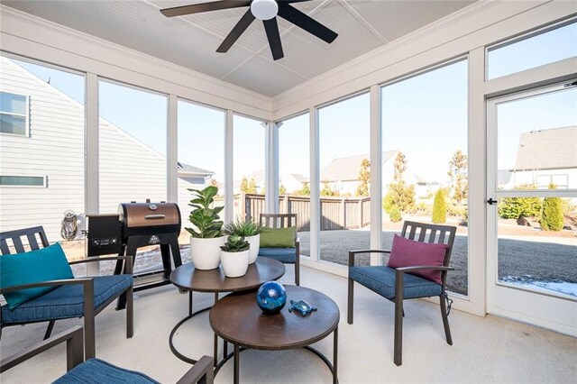 sunroom / solarium featuring a healthy amount of sunlight and ceiling fan