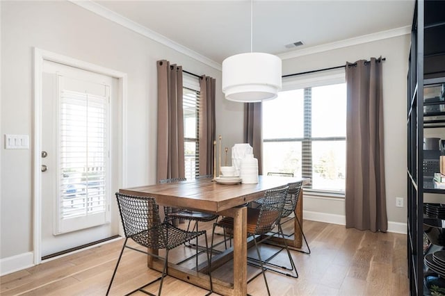 dining area featuring crown molding and light wood-type flooring