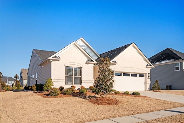 view of front of home with central AC unit and a garage