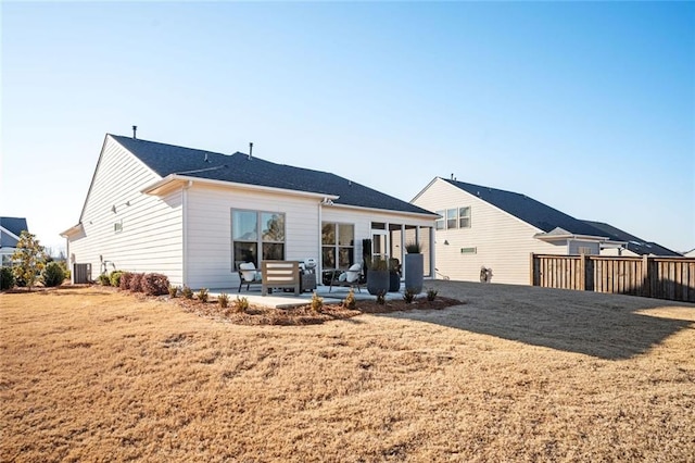 rear view of property with a yard, central AC unit, and a patio area