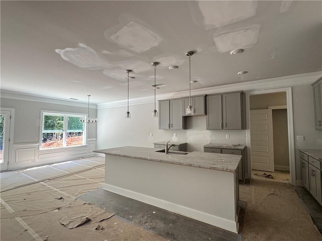 5381 Tuscany Dr, Douglasville, GA 30135 - kitchen featuring gray cabinets, crown molding, a kitchen island with sink, light stone counters, and pendant lighting
