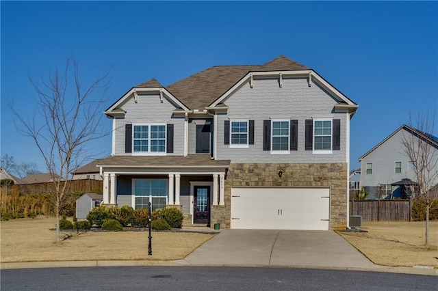 view of front of house with central air condition unit, a garage, fence, stone siding, and concrete driveway