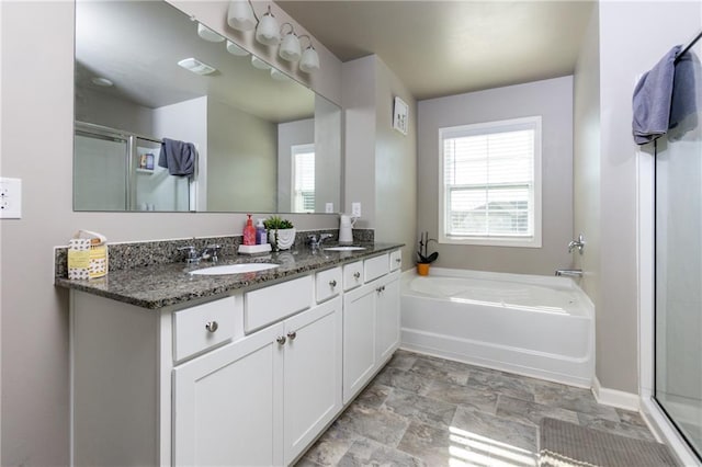 full bathroom with a wealth of natural light, a shower stall, and a sink