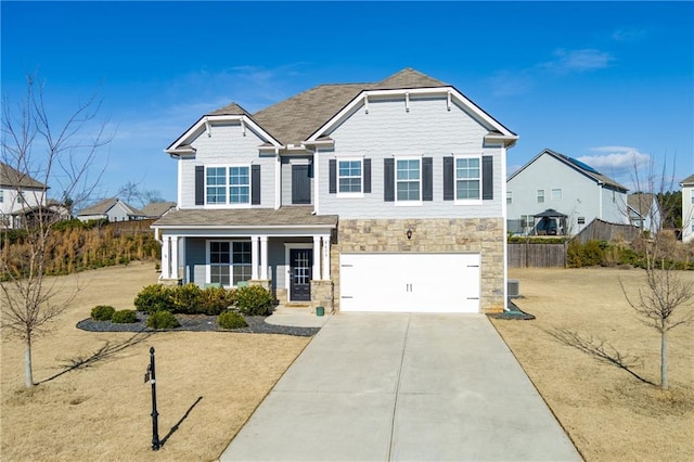 view of front of home featuring a porch, concrete driveway, an attached garage, fence, and stone siding