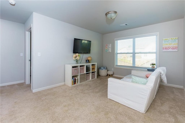 living room with carpet floors, visible vents, and baseboards