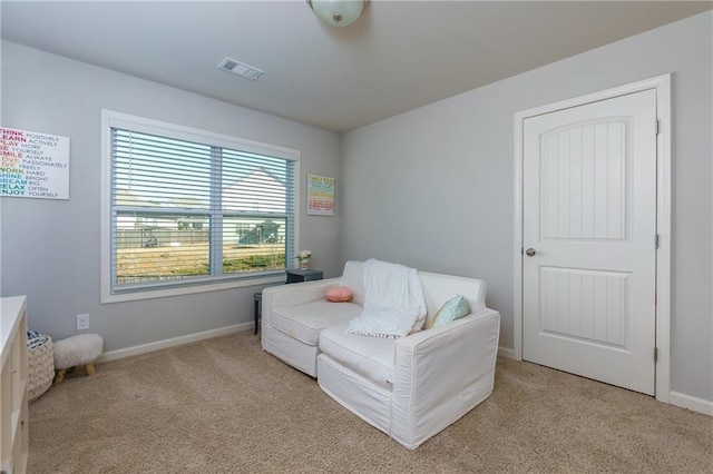 bedroom with baseboards, visible vents, and light colored carpet