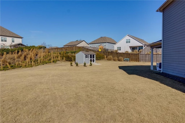 view of yard with a storage unit, an outdoor structure, and fence