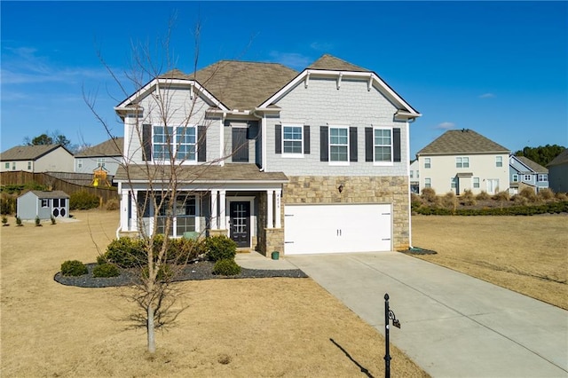 view of front of home with concrete driveway, stone siding, an attached garage, a porch, and a front yard