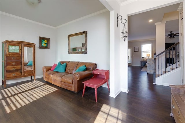 living room with stairs, baseboards, wood finished floors, and crown molding