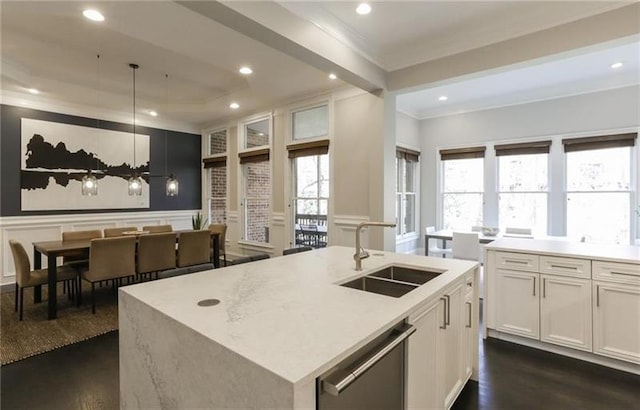 kitchen featuring sink, white cabinets, a center island with sink, decorative light fixtures, and stainless steel dishwasher