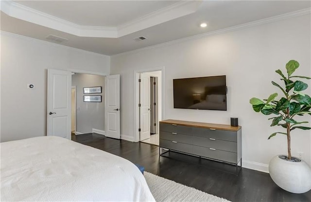 bedroom with dark hardwood / wood-style flooring, ornamental molding, and a raised ceiling