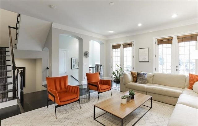 living room featuring french doors, ornamental molding, and light hardwood / wood-style floors