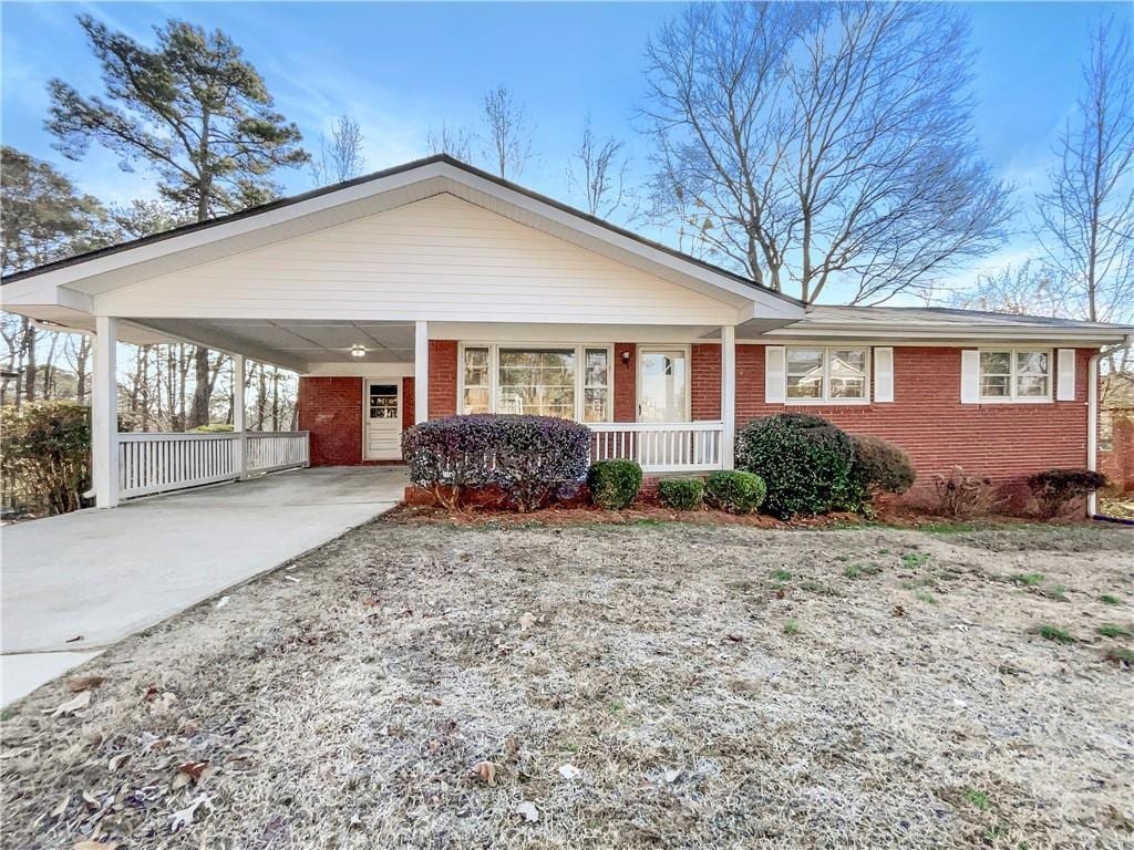 ranch-style home with a carport and covered porch