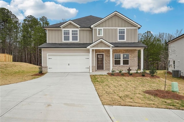 craftsman house with cooling unit, a front lawn, and a garage