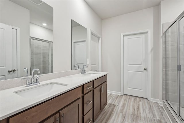 bathroom featuring a shower with door, vanity, and hardwood / wood-style floors