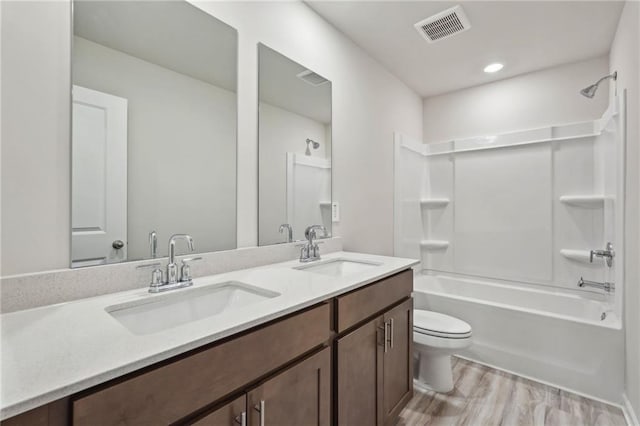 full bathroom with vanity, toilet, shower / tub combination, and wood-type flooring