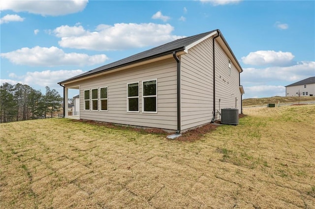 view of side of property featuring a yard and cooling unit