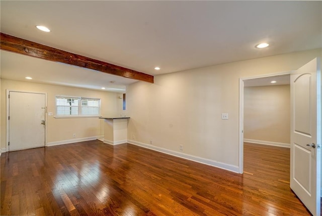 interior space with beam ceiling and dark hardwood / wood-style flooring