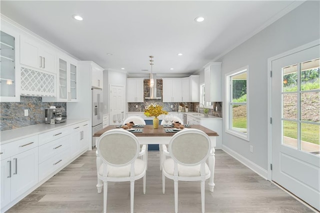 1226 Bloomsbury Ln, Gainesville, GA 30501 - kitchen with wall chimney exhaust hood, a sink, crown molding, tasteful backsplash, and white cabinetry