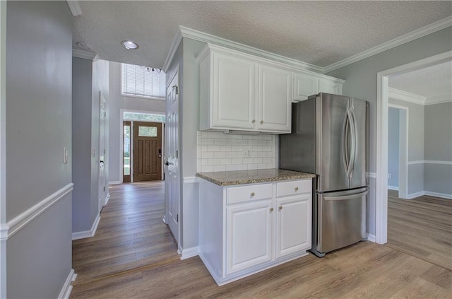 11 Trotters Walk NE, Cartersville, GA 30121 - kitchen featuring freestanding refrigerator, light wood-style floors, white cabinetry, a textured ceiling, and decorative backsplash
