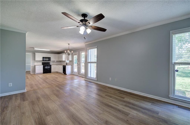 11 Trotters Walk NE, Cartersville, GA 30121 - unfurnished living room with a chandelier, ceiling fan, wood finished floors, a textured ceiling, and ornamental molding