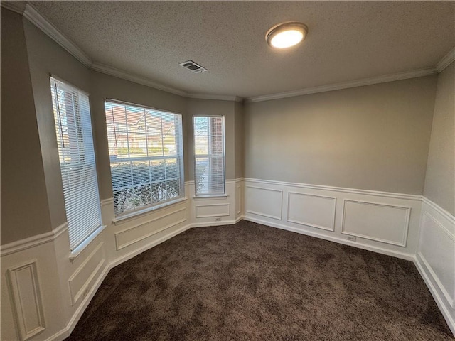 empty room featuring dark colored carpet, a textured ceiling, crown molding, and a healthy amount of sunlight