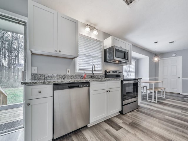 525 Henson Cir, Carrollton, GA 30117 - kitchen with stainless steel appliances, a sink, light wood-style flooring, light stone countertops, and white cabinets