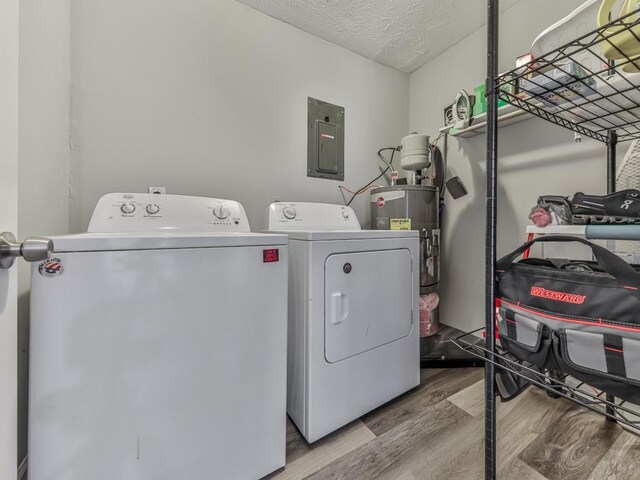 525 Henson Cir, Carrollton, GA 30117 - laundry area with electric panel, washing machine and dryer, wood finished floors, water heater, and a textured ceiling