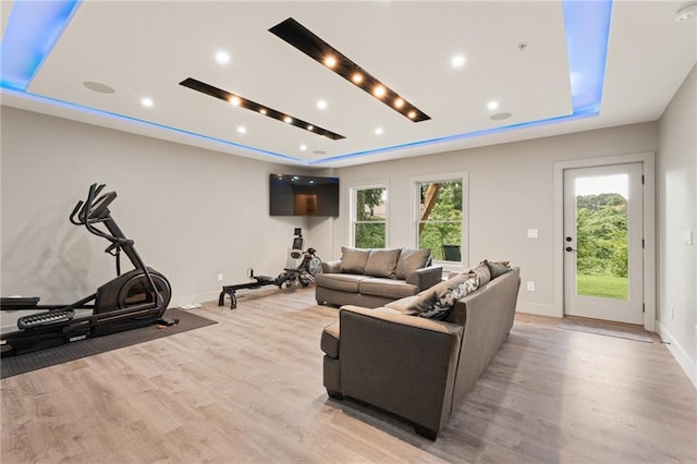 living room with light hardwood / wood-style flooring and a tray ceiling