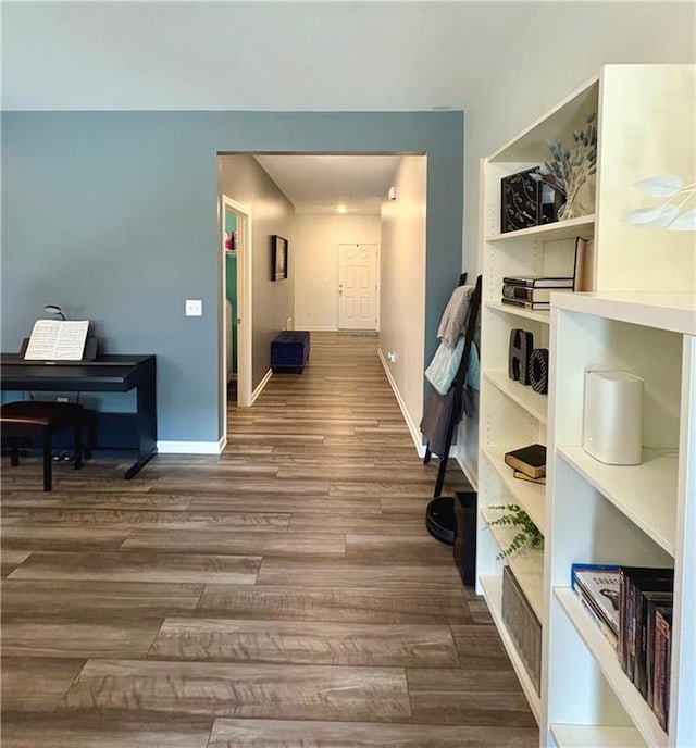 hallway with baseboards and wood finished floors