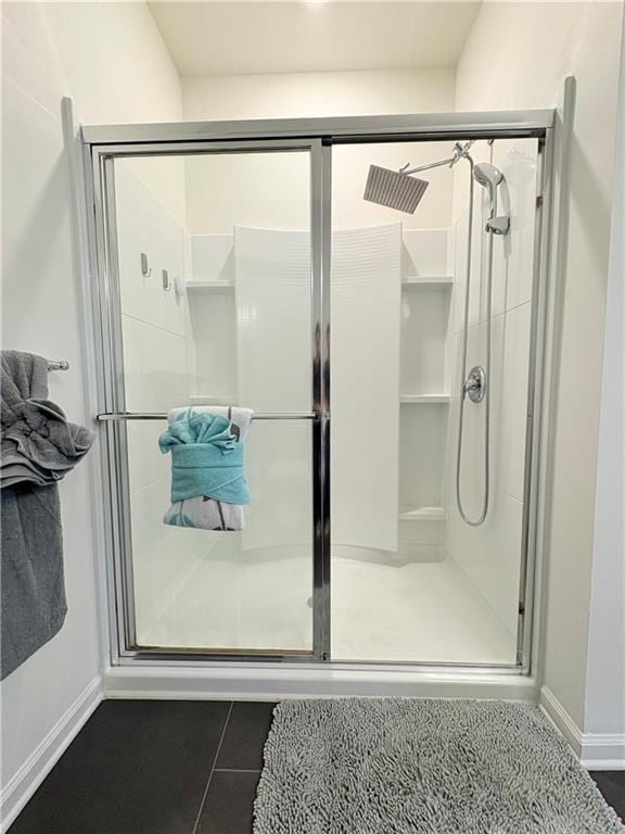 full bathroom with tile patterned floors, baseboards, and a stall shower