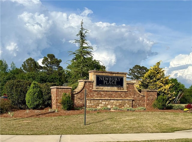 community / neighborhood sign featuring a lawn