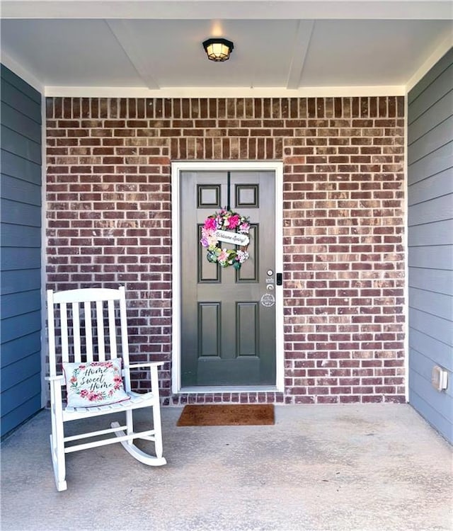 doorway to property with brick siding