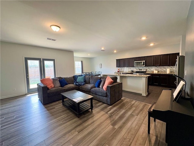 living area featuring dark wood-type flooring, recessed lighting, and visible vents