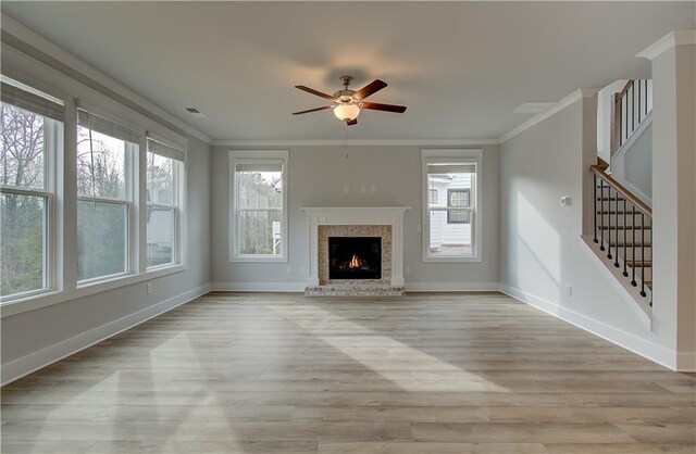 unfurnished living room with ceiling fan, plenty of natural light, crown molding, and light hardwood / wood-style flooring